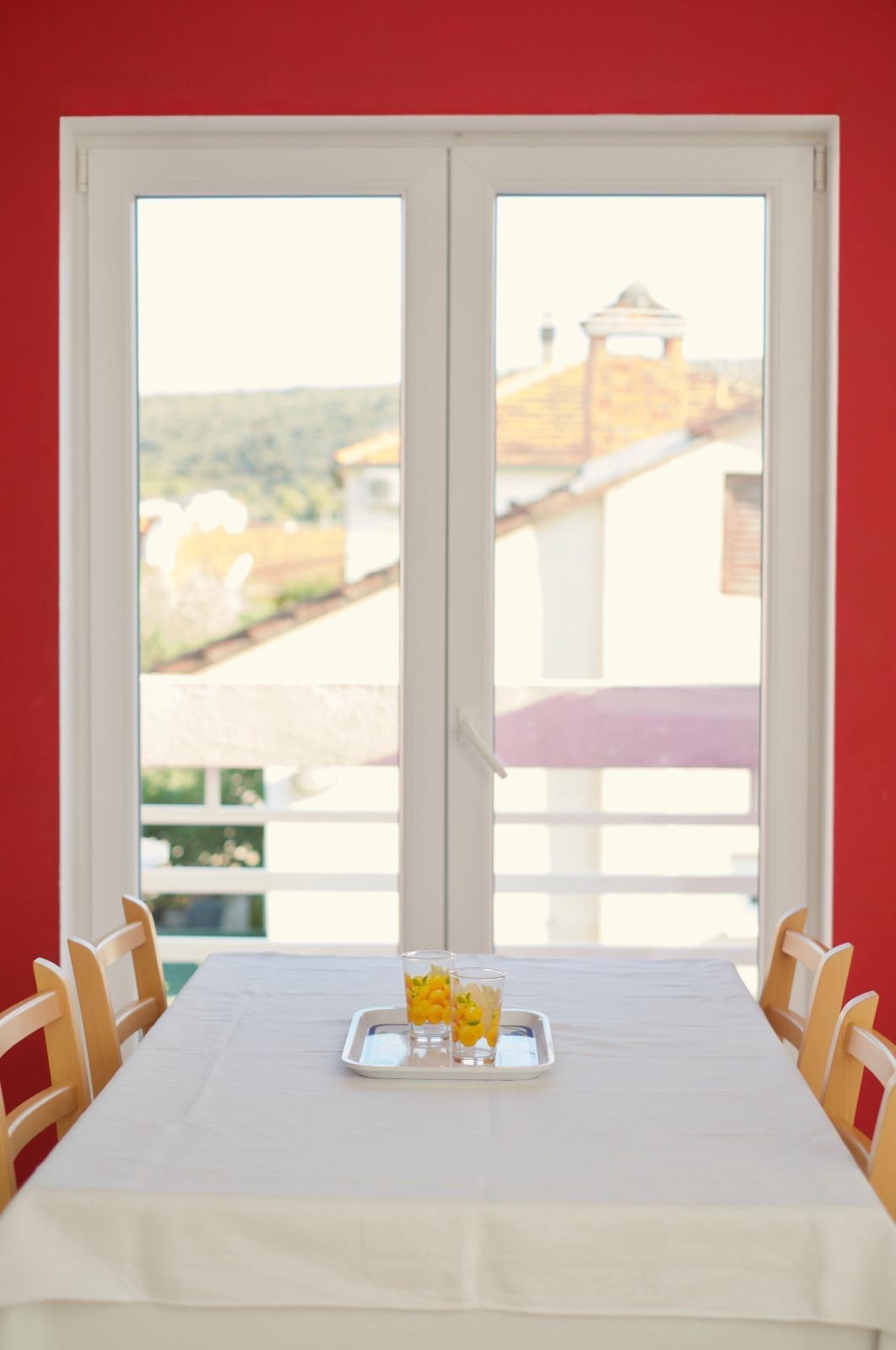 Dining area with a view through the balcony doors towards Vinišće