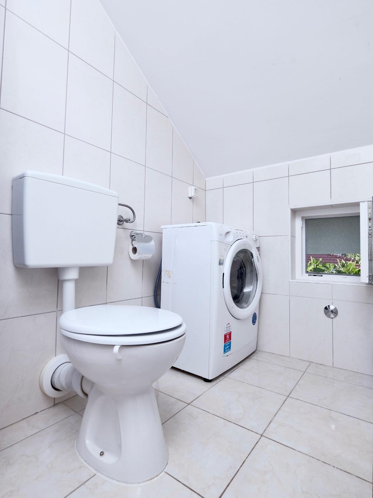 Clean private bathroom with washing machine in Apartman Vinišće
