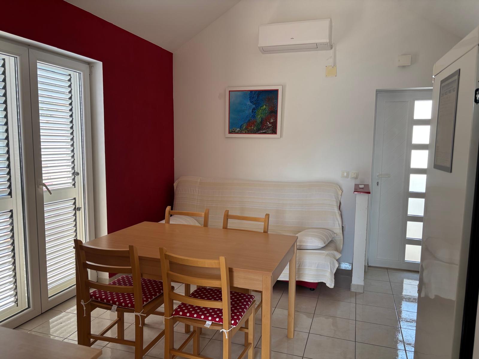 Sunny living and dining area with sofa and balcony doors
